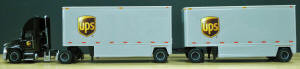 T SP - 159 		Mack day cab and drop frame double 28 ft trailers - UPS